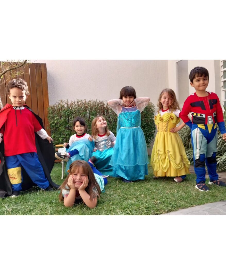 Crianças da Escola Jeitinho de Criança fantasiadas de super-heróis e princesas no jardim da escola