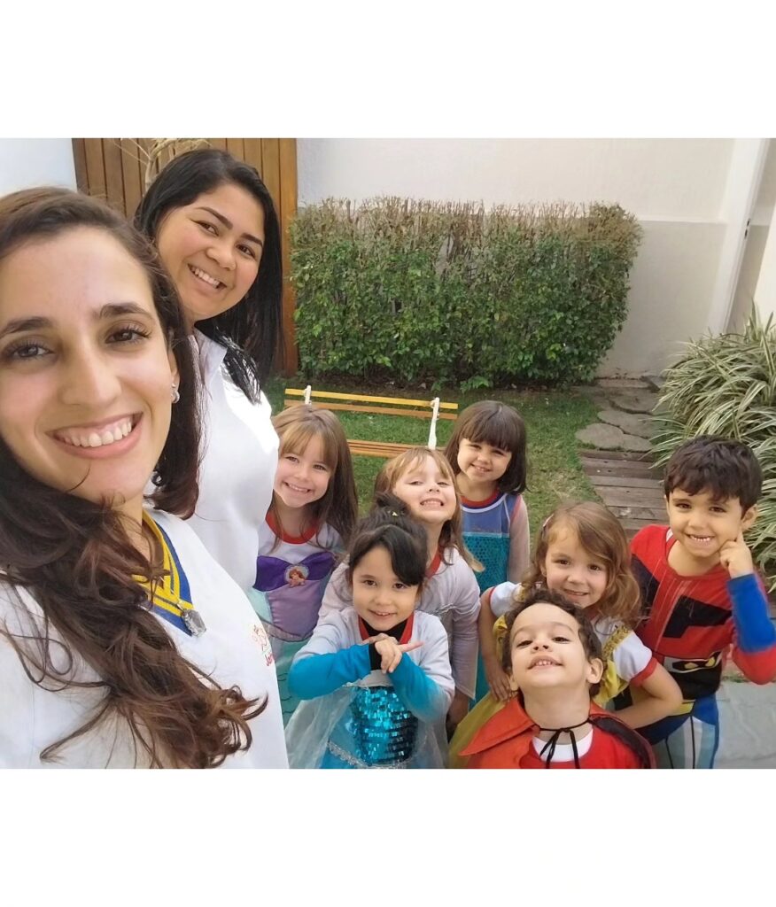 Professoras e crianças fantasiadas sorrindo juntas em selfie na Escola Jeitinho de Criança